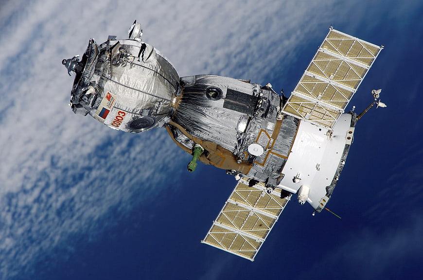 Soyuz spacecraft orbiting Earth with solar panels