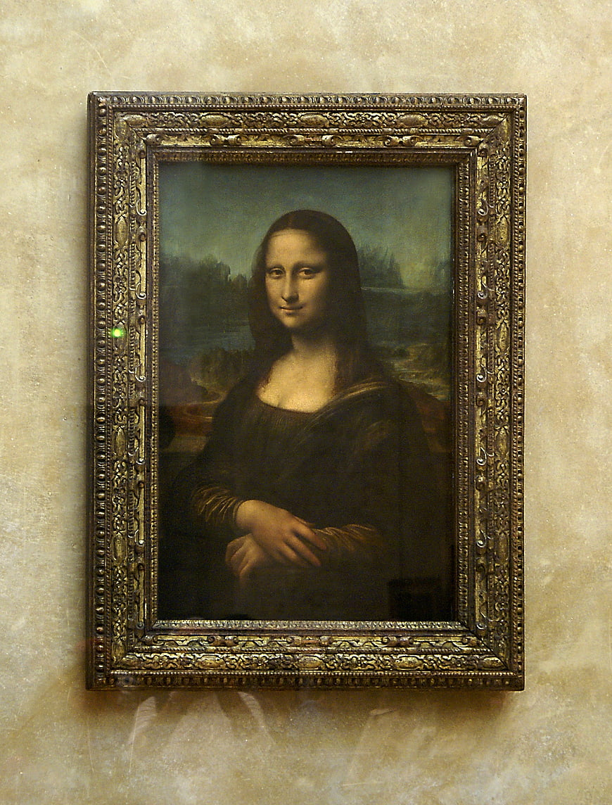 Mona Lisa painting in ornate gold frame on museum wall