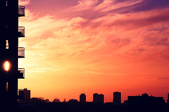 Vibrant Sunset Skyline with Silhouetted City Buildings