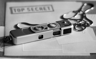 Vintage spy camera on top secret document