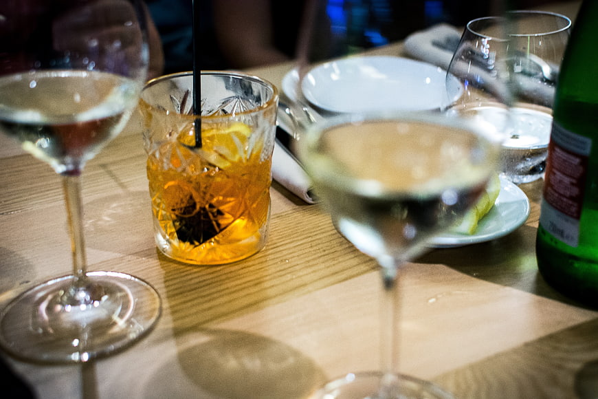 Cocktails and wine glasses on a wooden restaurant table