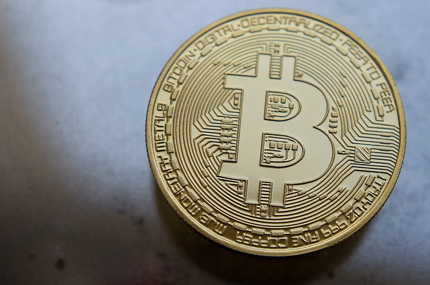 Gold Bitcoin Coin Close-Up on Textured Surface