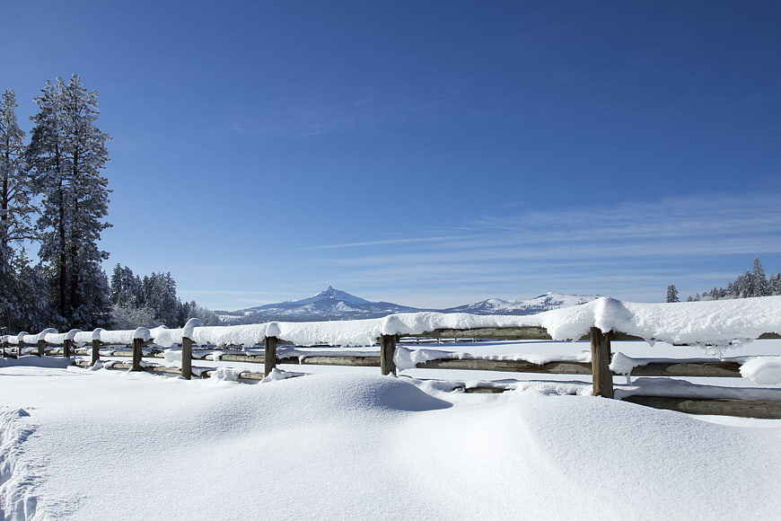 Snowy Winter Landscape with Wooden Fence and Mountain View