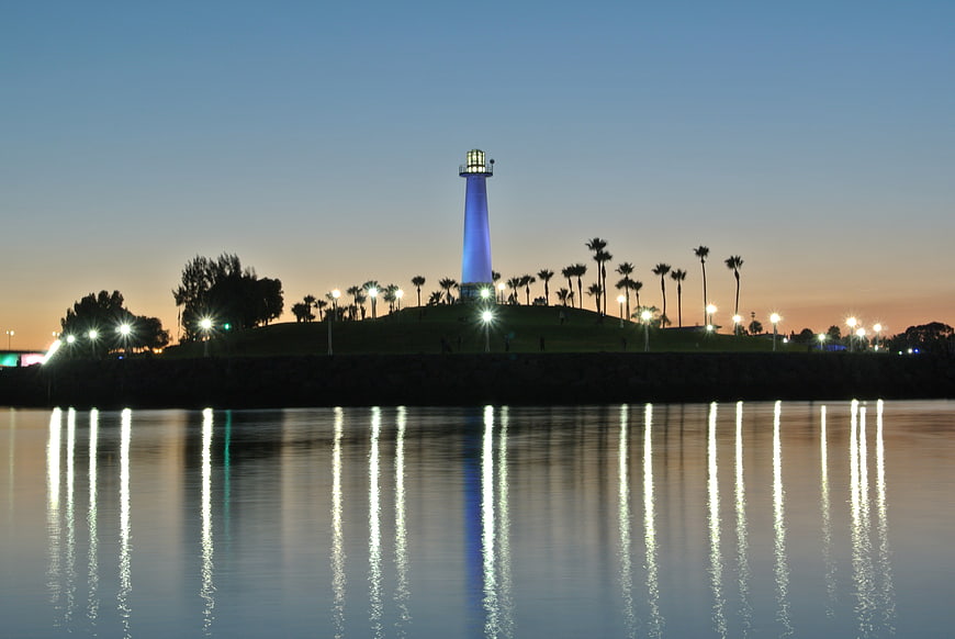 Lighthouse with blue light reflecting in water at dusk