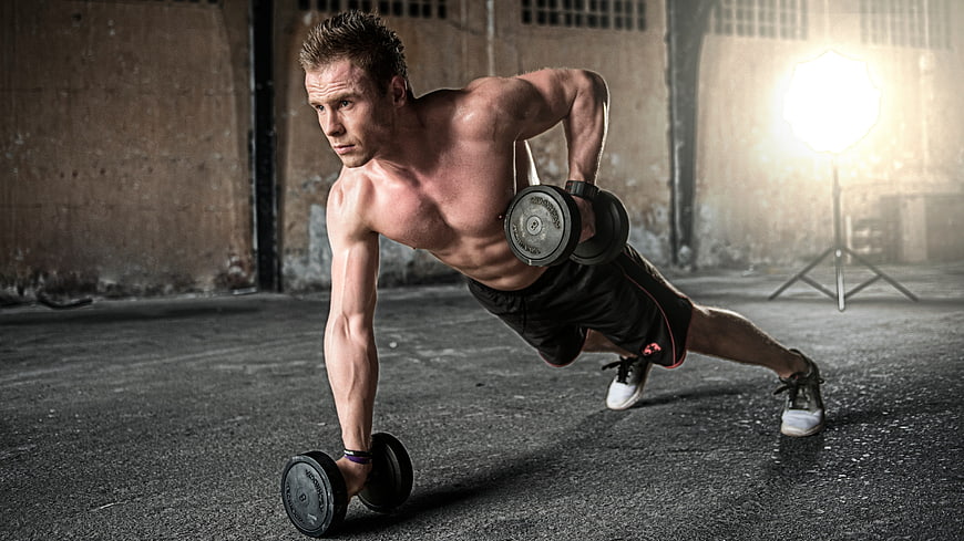 Muscular Man Performing Dumbbell Row in Industrial Gym