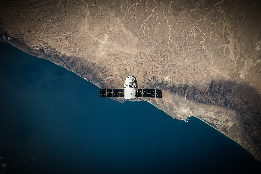 Spacecraft in Orbit Over Earth's Coastline