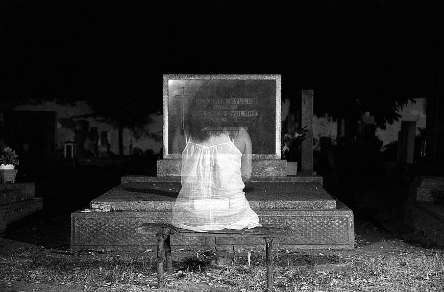 Ghostly Woman Sitting on Grave at Night Cemetery