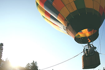 Colorful Hot Air Balloon Launching with Flame Against Blue Sky