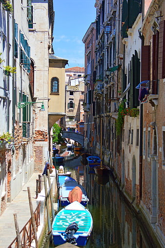 Narrow Venetian Canal with Moored Boats and Old Buildings