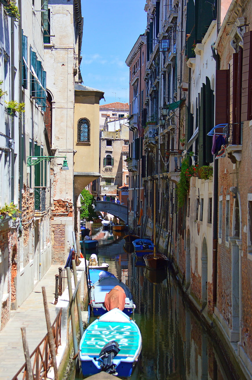 Narrow Venetian Canal with Moored Boats and Old Buildings