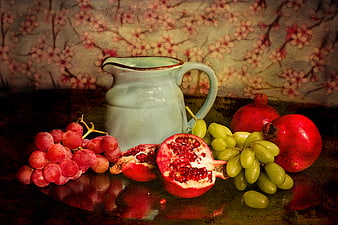 Vintage still life with pomegranates, grapes, and ceramic pitcher