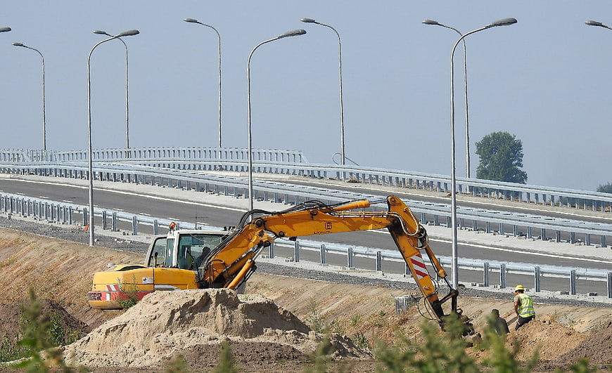 Yellow Excavator Digging Near New Highway Viaduct Construction Site