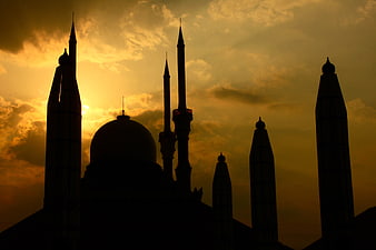 Silhouette of Mosque Minarets Against Golden Sunset Sky