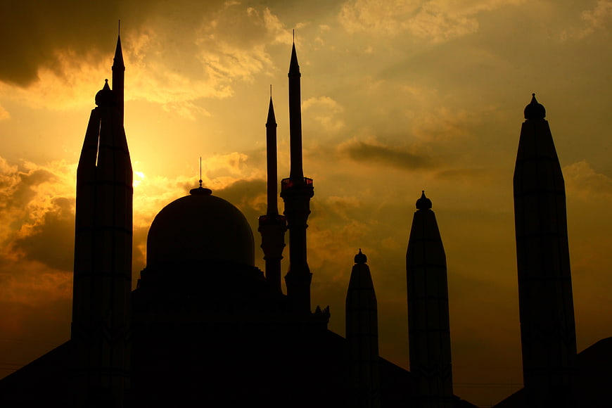 Silhouette of Mosque Minarets Against Golden Sunset Sky