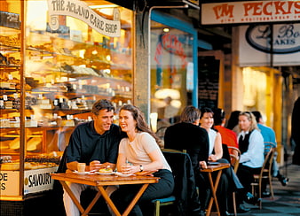 Couple Enjoying Coffee And Cake At Outdoor Cafe