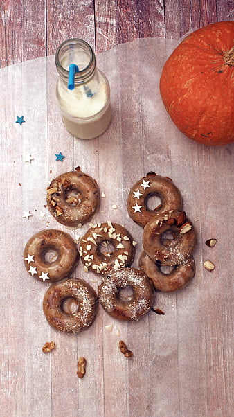 Baked pumpkin donuts with milk and autumn decorations