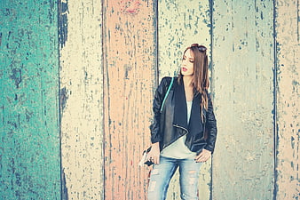 Stylish Woman in Leather Jacket Against Colorful Wall
