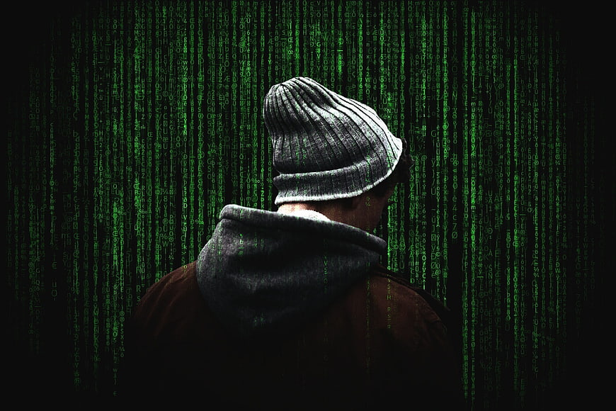 Anonymous Hacker in Beanie with Green Matrix Code Background