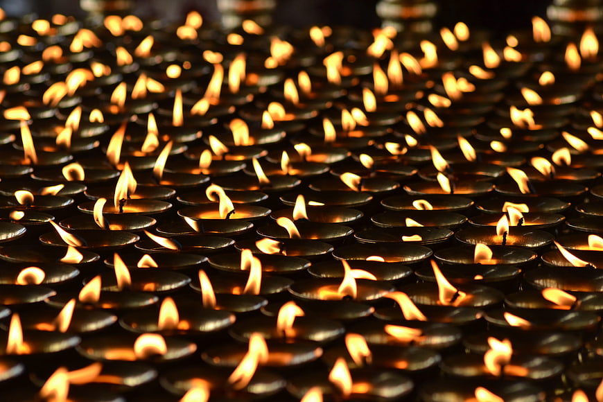 Rows of traditional oil lamps glowing in a temple