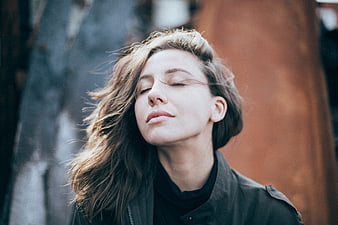 Serene woman with eyes closed enjoying the wind outdoors