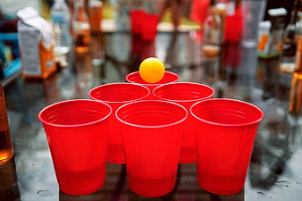 Red plastic cups and yellow ball for beer pong game