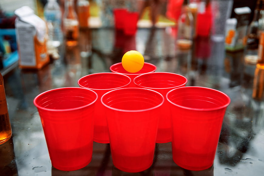 Red plastic cups and yellow ball for beer pong game