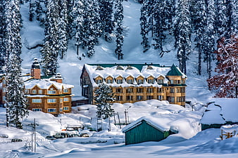Snow-covered wooden chalets in a Himalayan winter landscape