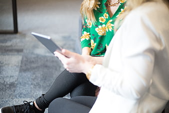 Two women collaborating on a tablet in an office setting