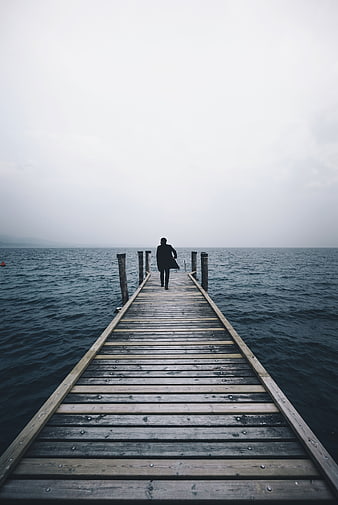Man in Suit Walking on Wooden Pier into Foggy Sea