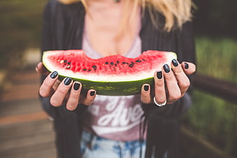 Woman holding slice of fresh watermelon outdoors