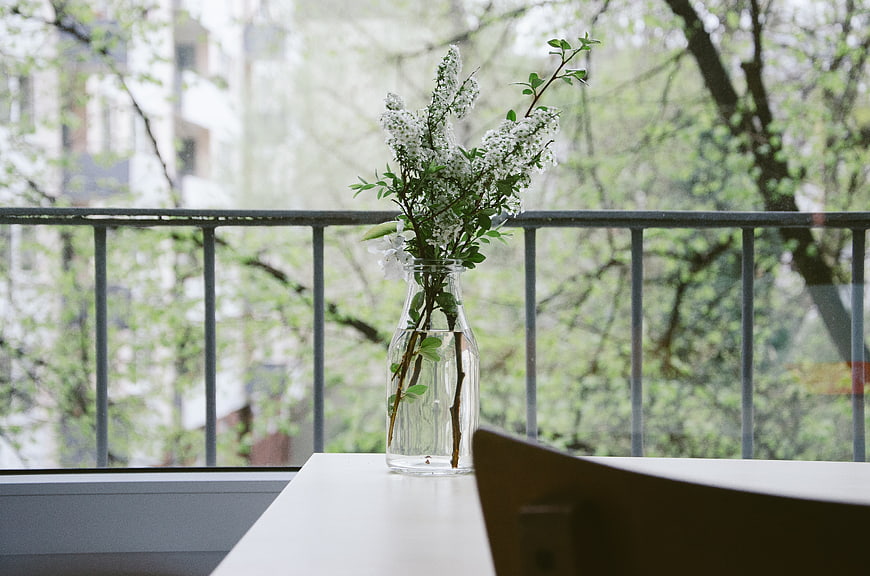 White flowers in glass vase on balcony table