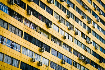 Yellow Residential Building Facade with Windows and Air Conditioners