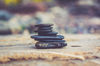 Stacked Zen Stones on Wooden Surface with Blurred Background