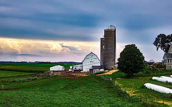 Rural Farm Landscape with Silos and Barn Under Dramatic Sky