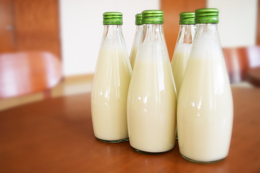 Glass Bottles of Fresh Milk on Wooden Table