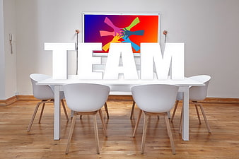 White TEAM letters on modern office table with colorful background