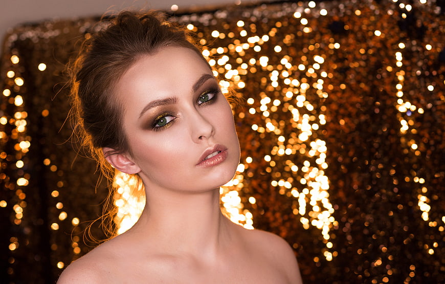 Elegant woman portrait with gold glitter background