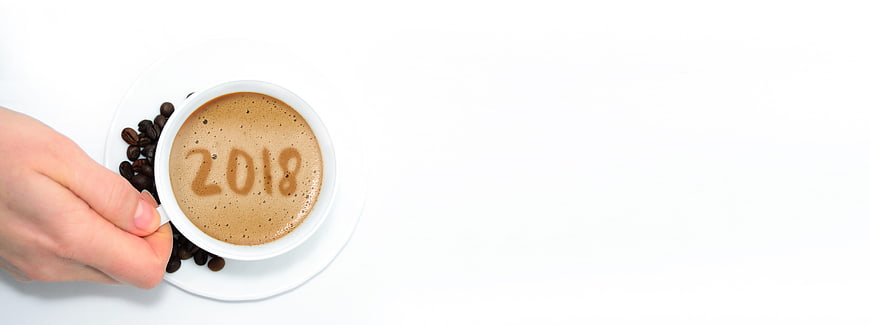 Hand holding coffee cup with 2018 written in foam