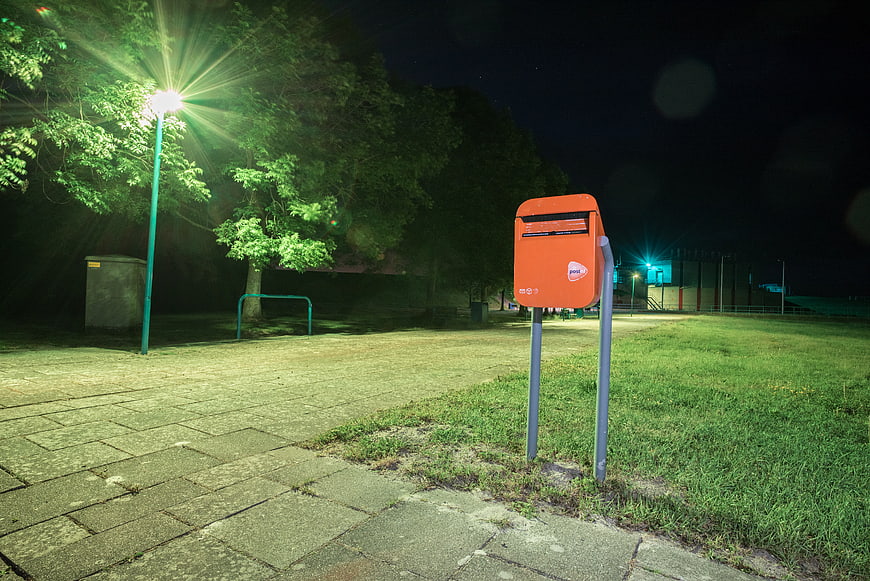 Orange Post Box on Grass at Night