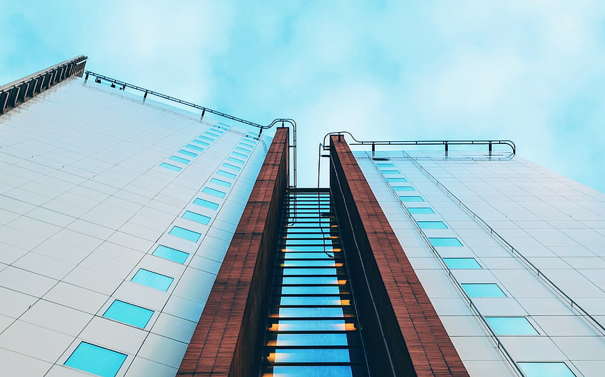 Low angle view of modern skyscraper architecture against blue sky