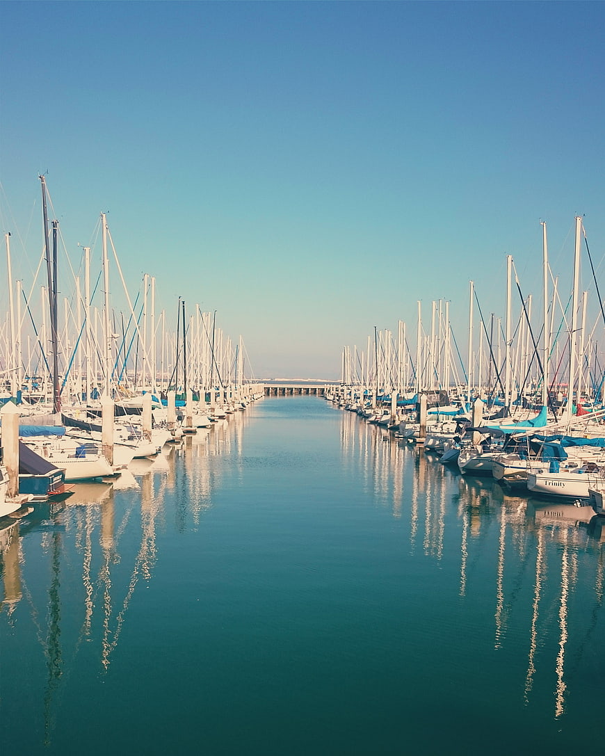 Symmetrical Marina with Sailboats and Blue Sky Reflection