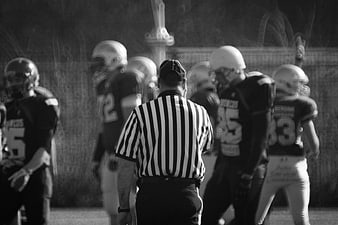 American Football Referee and Players on Field
