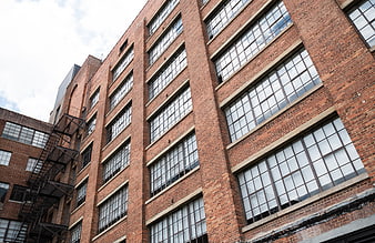 Low angle view of red brick industrial building facade