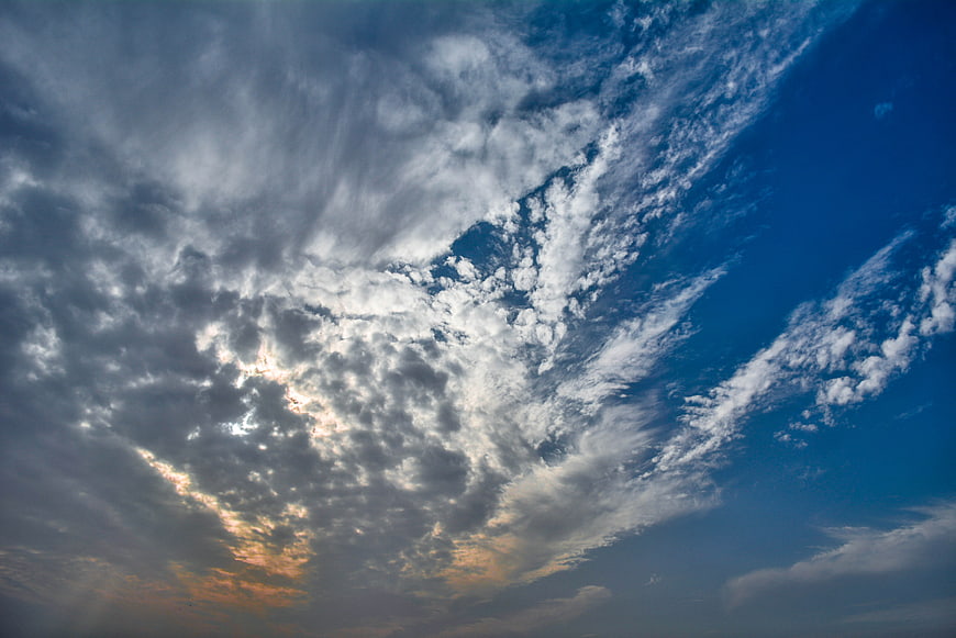 Dramatic blue sky with textured clouds and sunset glow