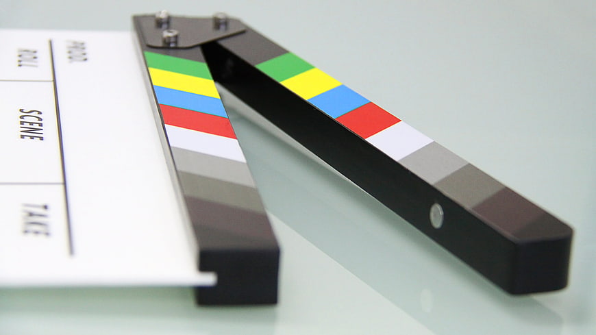 Close-up of a film clapperboard on a white surface
