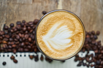 Top View of Latte Art with Coffee Beans on Wood