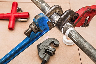 Plumbing tools and wrenches on tiled floor