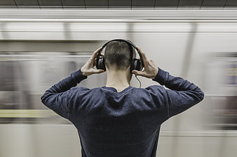 Man listening to music on headphones at subway station