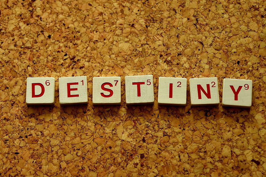 Scrabble tiles spelling destiny on a textured cork background