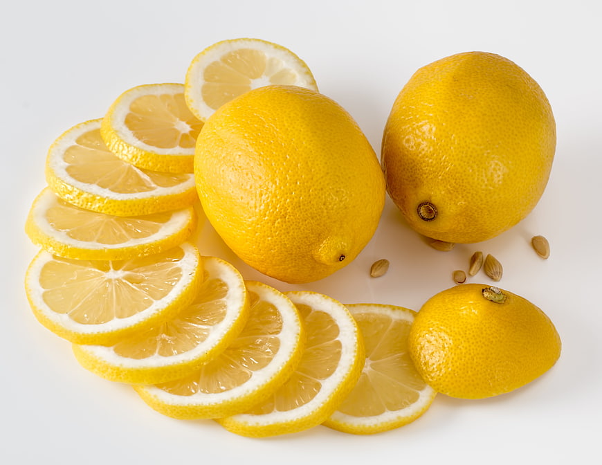 Fresh Yellow Lemons and Slices on White Background